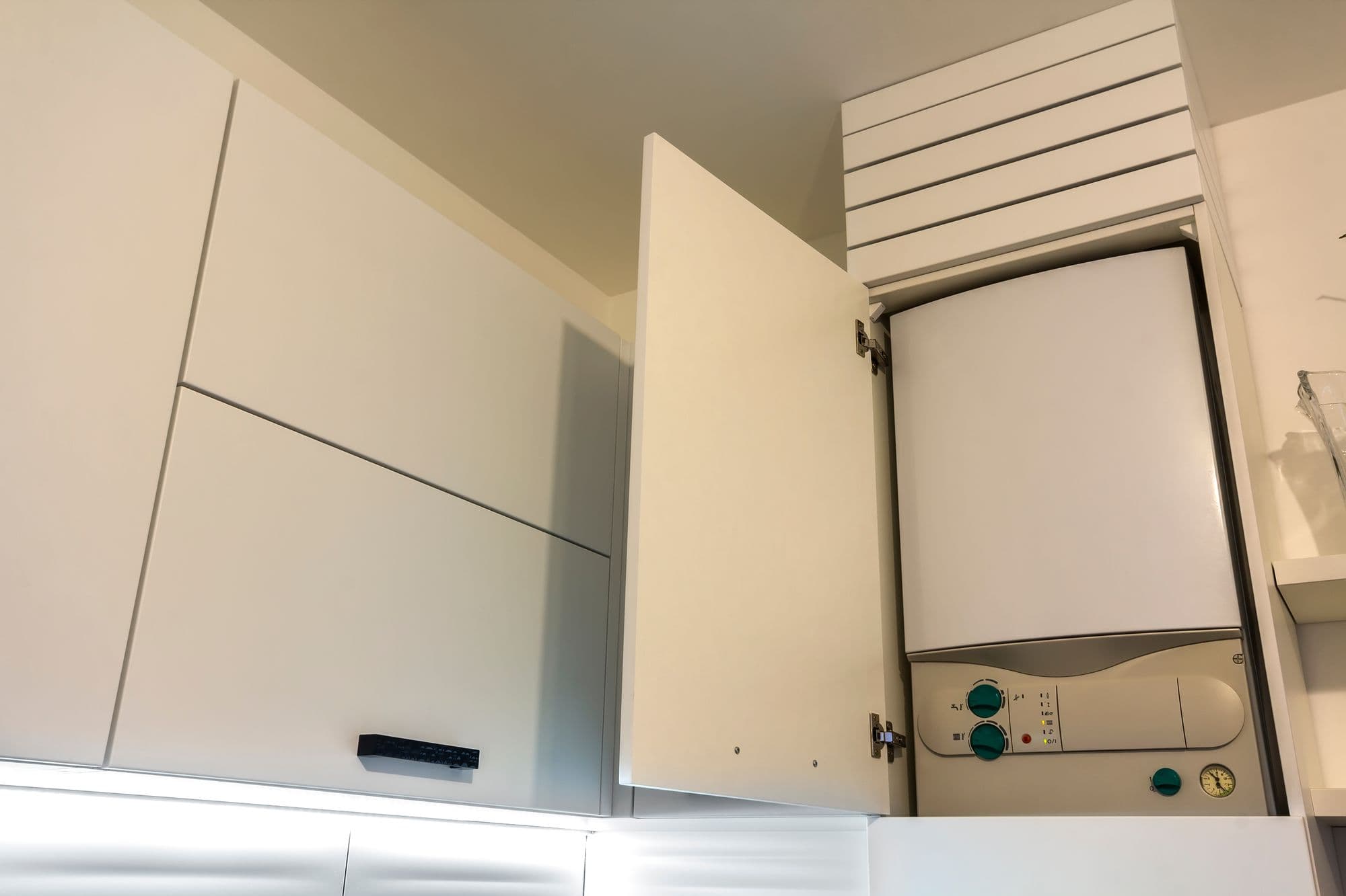 Boiler housed in a wall cabinet above modern kitchen units